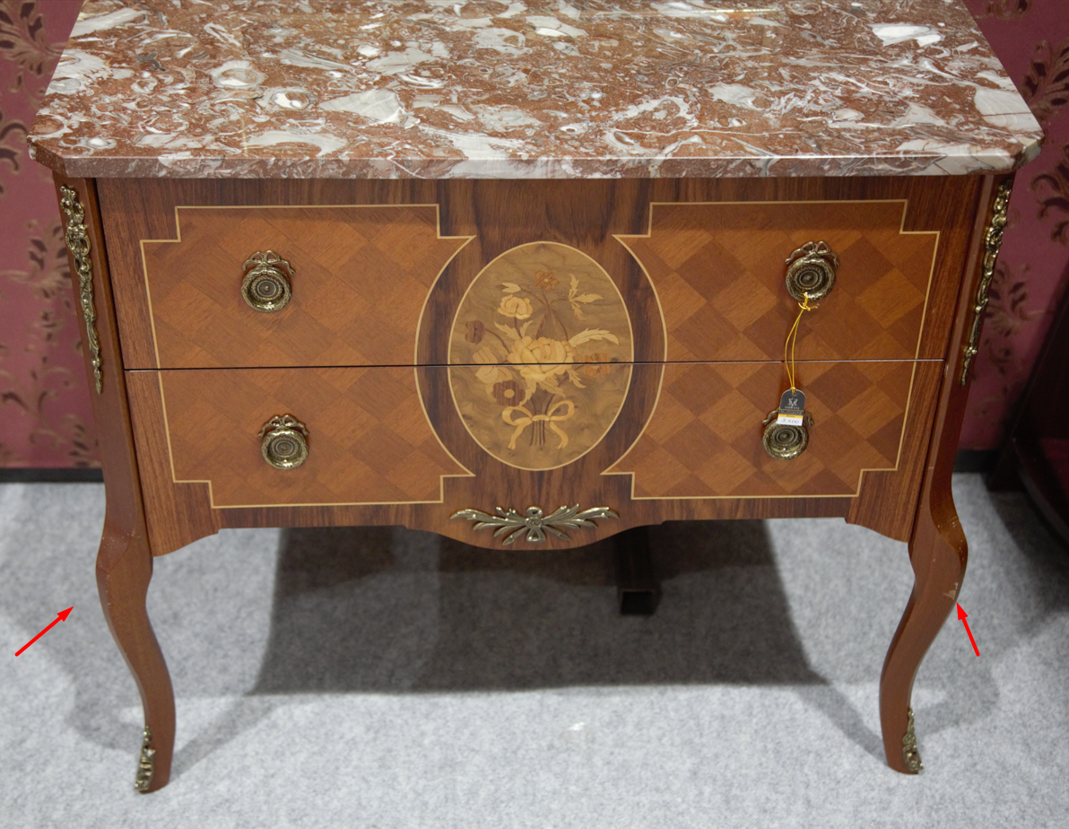 Front view of a vintage French Louis XVI style wooden commode with two drawers, a central oval floral marquetry design, and a red marble top.
