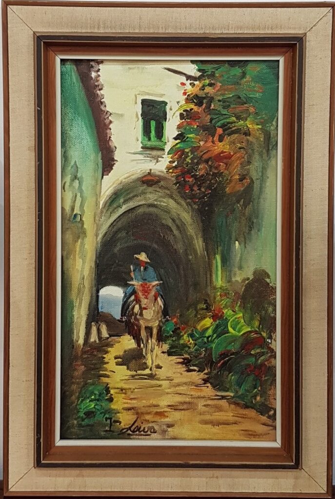 Original mid-century oil painting by T. Loiva, depicting a man riding a donkey through a rustic arched village street with colorful cascading flowers, enclosed in a vintage fabric-lined wooden frame.