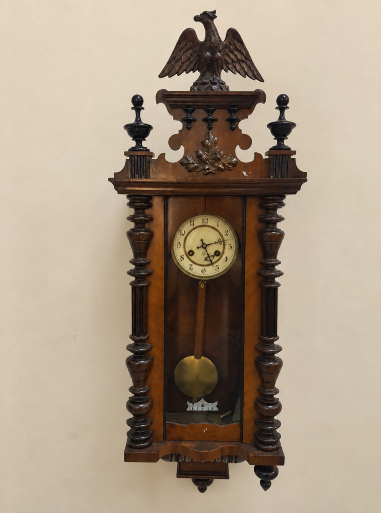 Antique German Vienna Regulator wall clock, c. 1880–1900, featuring an ornate carved wooden case with eagle crest, decorative columns, classic dial, and brass pendulum.