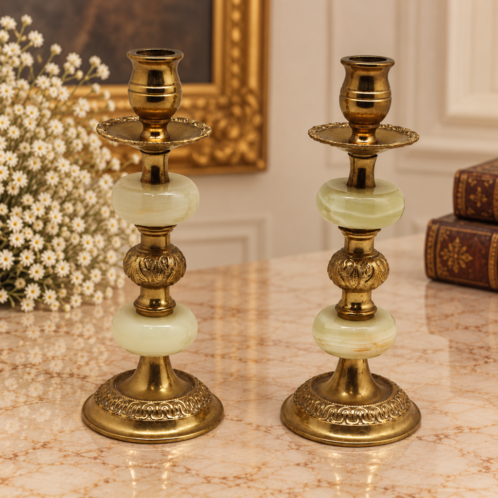 A matching pair of vintage French style gilt brass candlesticks with ornate floral relief bases and polished green onyx stone orbs on a white background.