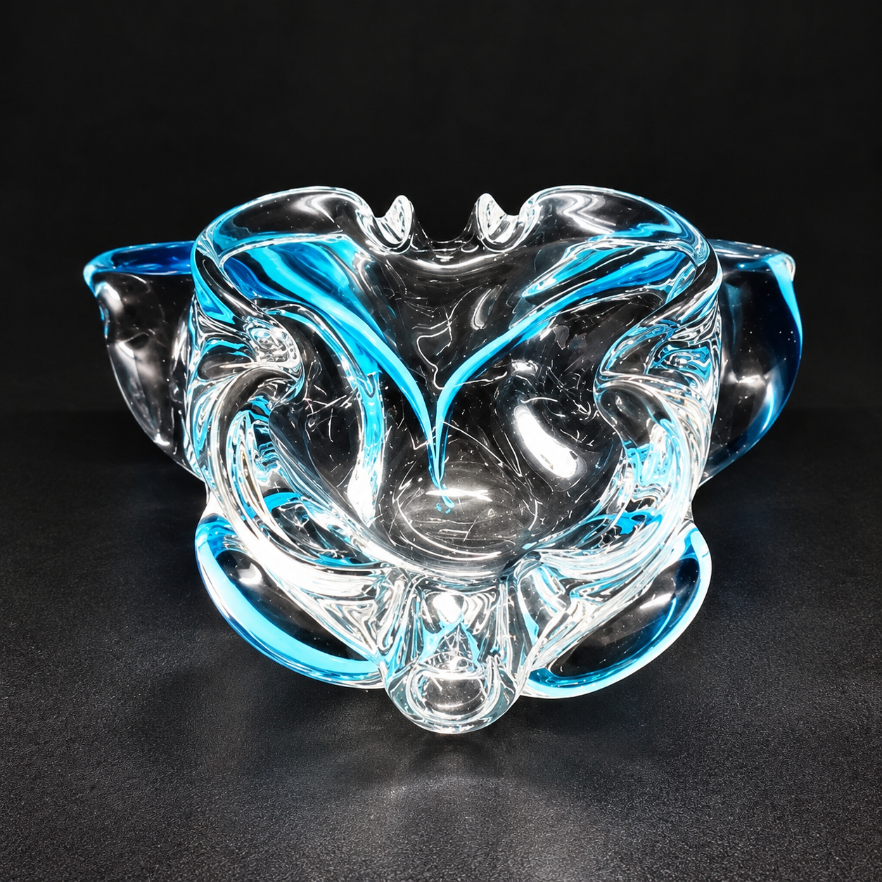 Heavy vintage Italian Murano hand-blown art glass bowl featuring an organic biomorphic splash design with vivid turquoise blue glass submerged inside a thick clear glass body.