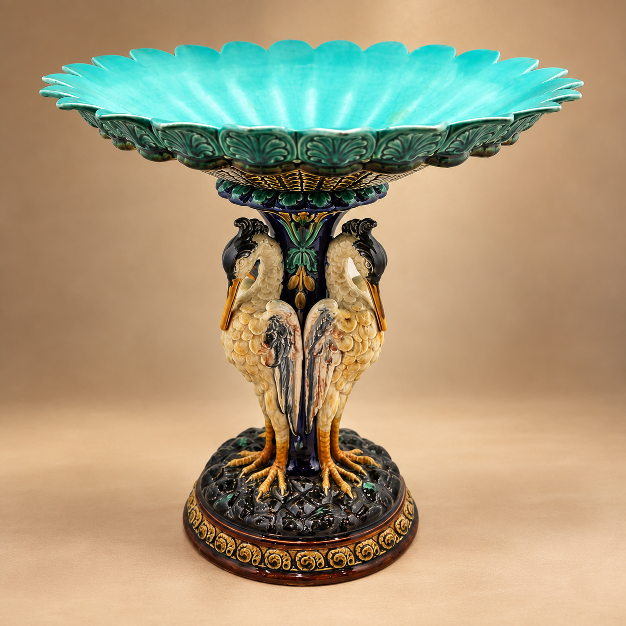 Antique Swedish Rörstrand majolica centerpiece bowl supported by a pedestal base shaped like three storks with a vibrant turquoise blue interior.