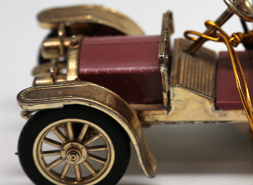 Vintage Gama Germany 1:43 scale diecast model of a 1902 Mercedes Simplex classic car, featuring a maroon body, tan seats, black folding canopy roof, and bright gold fenders and wheels.