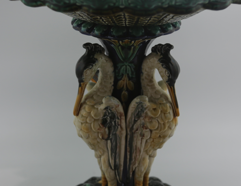 Antique Swedish Rörstrand majolica centerpiece bowl supported by a pedestal base shaped like three storks with a vibrant turquoise blue interior.