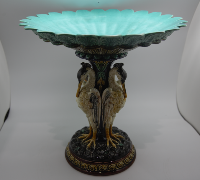 Antique Swedish Rörstrand majolica centerpiece bowl supported by a pedestal base shaped like three storks with a vibrant turquoise blue interior.