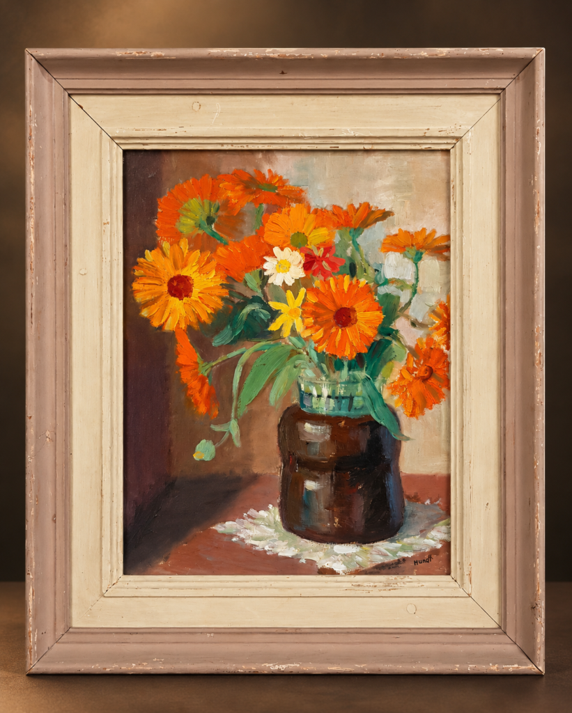 A mid-century floral still life oil painting by German artist Friedrich Wilhelm Hundt, depicting a vibrant bouquet of orange and yellow calendula flowers in a dark vase resting on a white lace doily, enclosed in a vintage wooden frame.