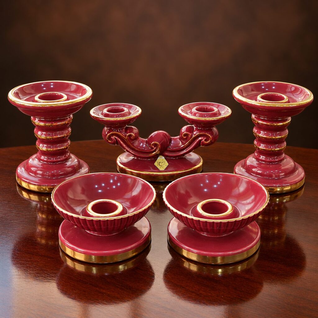 Vintage 1940s Swedish Gefle Röd Rubin five-piece ruby-red glazed ceramic candlestick set with gold-gilt accents, featuring two tall candlesticks, a double-arm holder and two low fluted candleholders.