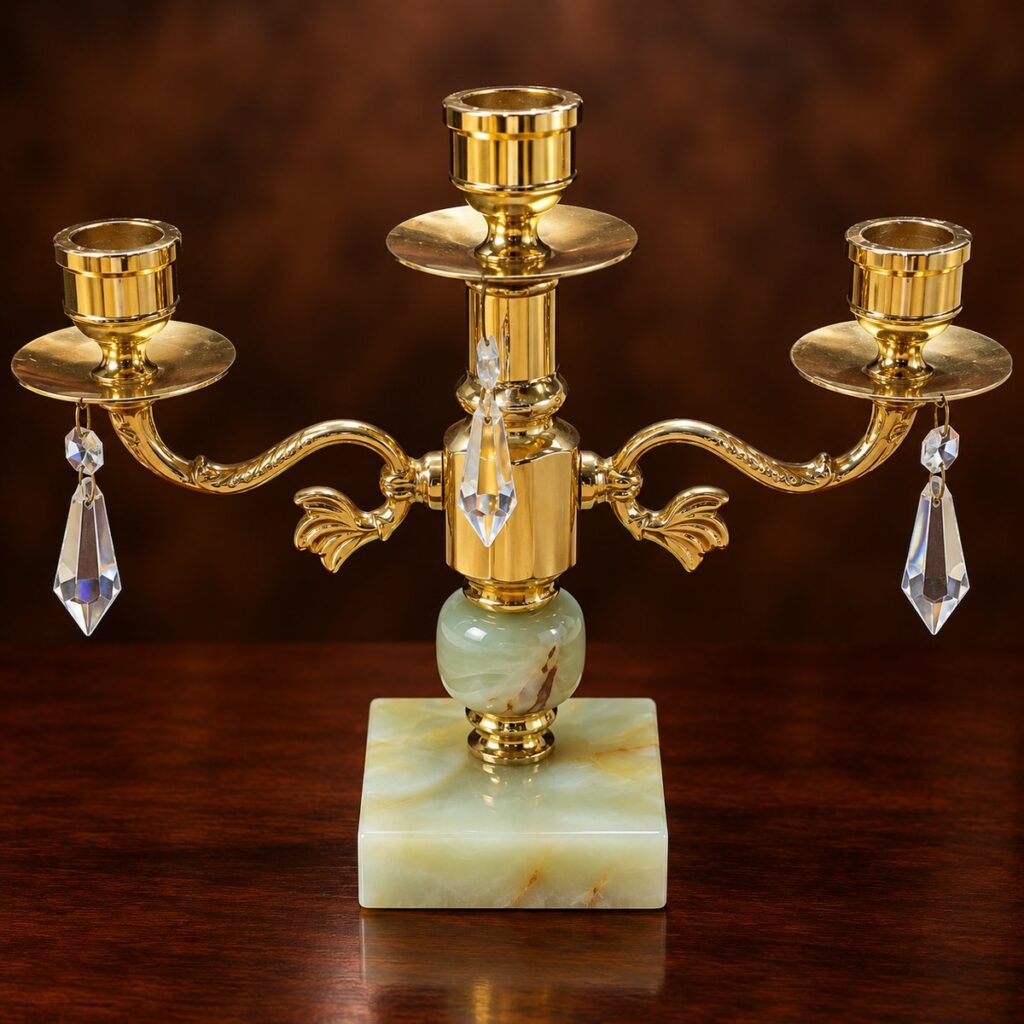 Vintage 1970s Italian-style three-arm brass candelabra with polished gold-tone finish, pale green onyx square base, decorative curved arms and hanging faceted crystal prisms.