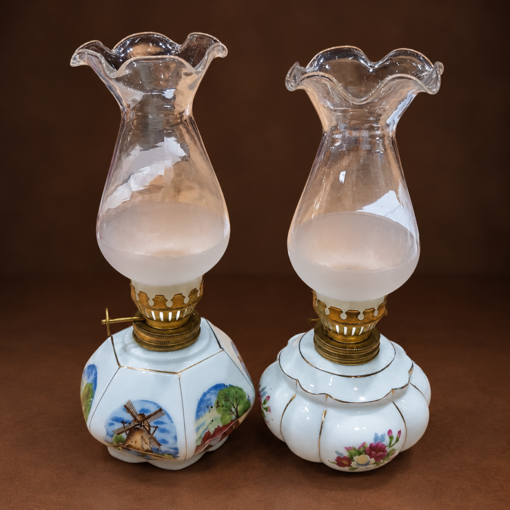 Pair of vintage miniature porcelain oil lamps with windmill and floral decorated bases, brass-tone fittings, and frosted ruffled glass chimneys.