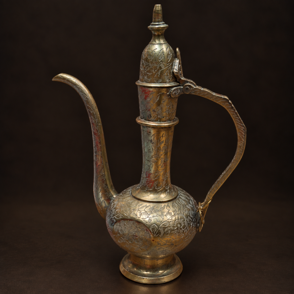 Vintage Persian-style hand-engraved brass ewer with floral decoration, long curved spout, sweeping handle and hinged lid, c. 1960s.