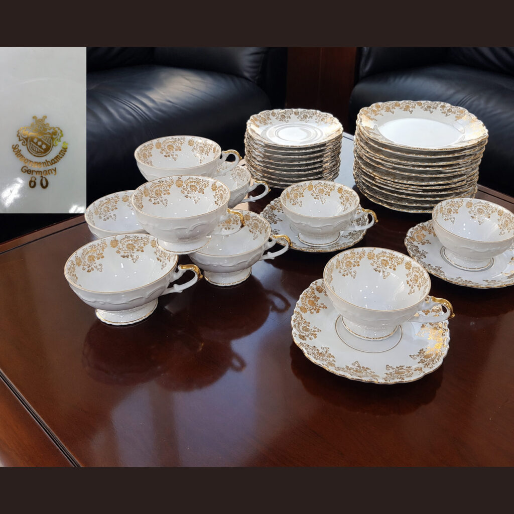 Vintage Schwarzenhammer Germany 31-piece white porcelain tea set with ornate gold floral patterns, scalloped plates, teacups and saucers, featuring the original manufacturer's gold backstamp.